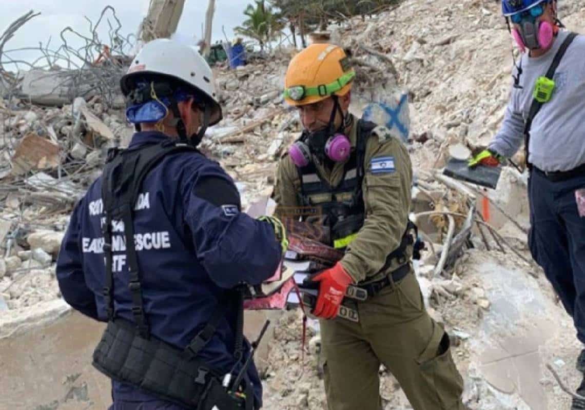 האסון בפלורידה: תמונה מרגשת וטראגית של קצין ישראלי שחילץ ספרי קודש מההריסות הופצה בכל העולם