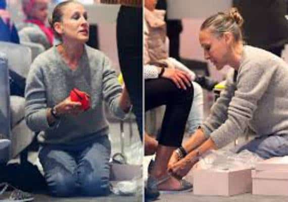 שרה ג'סיקה פרקר בתפקיד מוכרת נעליים: השחקנית כרעה ברך כדי לסייע לקונה בחנות הנעליים שבבעלותה